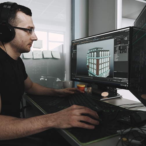 man in black tank top wearing black sunglasses using computer