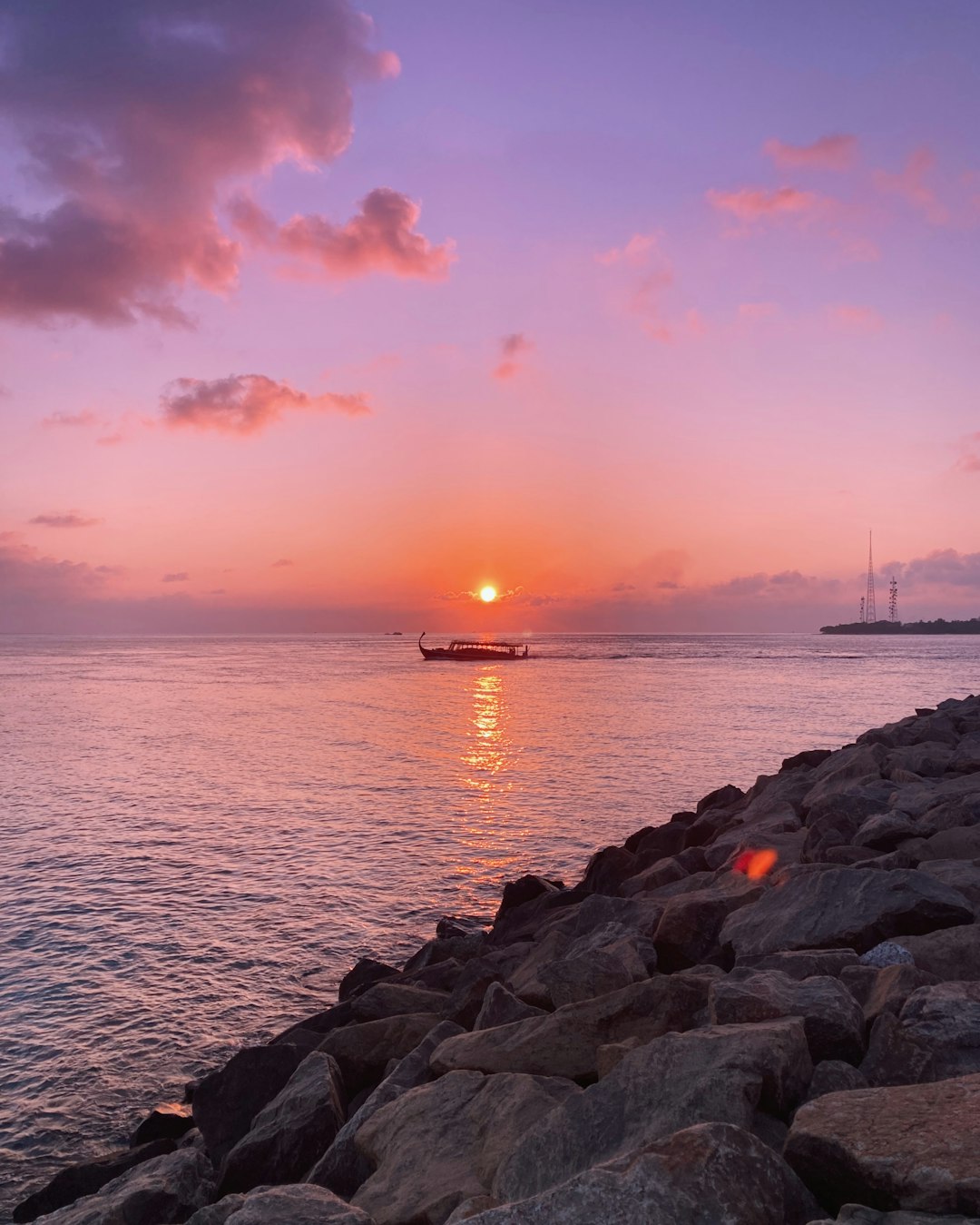 brown rocks near body of water during sunset