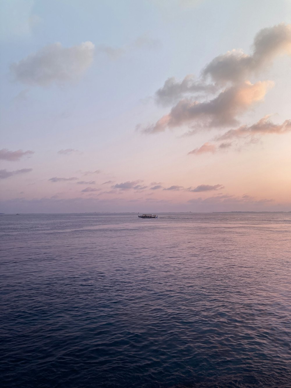 boat on sea under cloudy sky during daytime