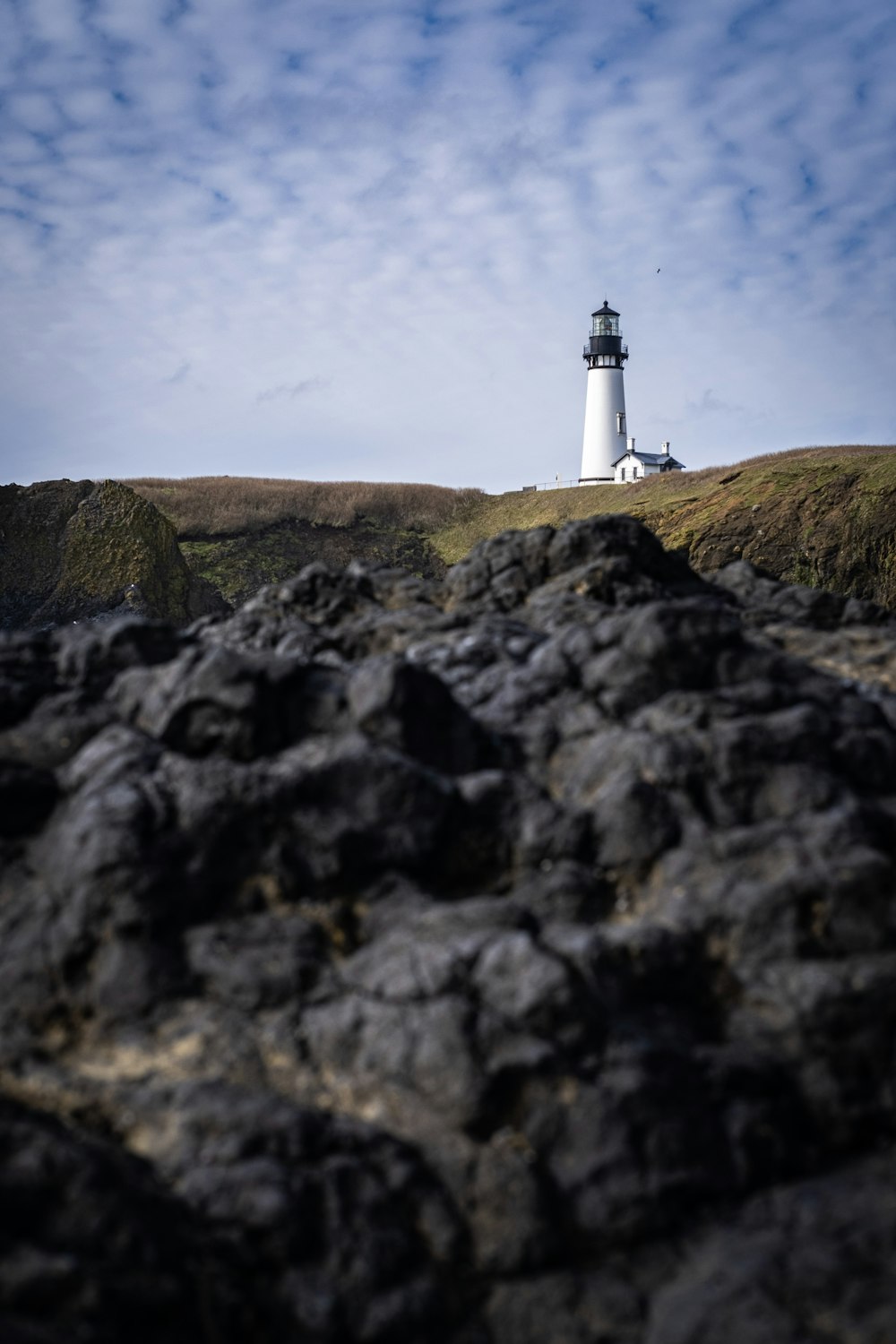 white lighthouse on green grass field under blue sky during daytime