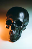 Close-up of a black t-shirt with a bold skull graphic under moody lighting.
