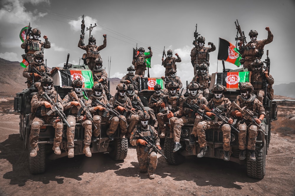 a group of military men riding on the back of a truck