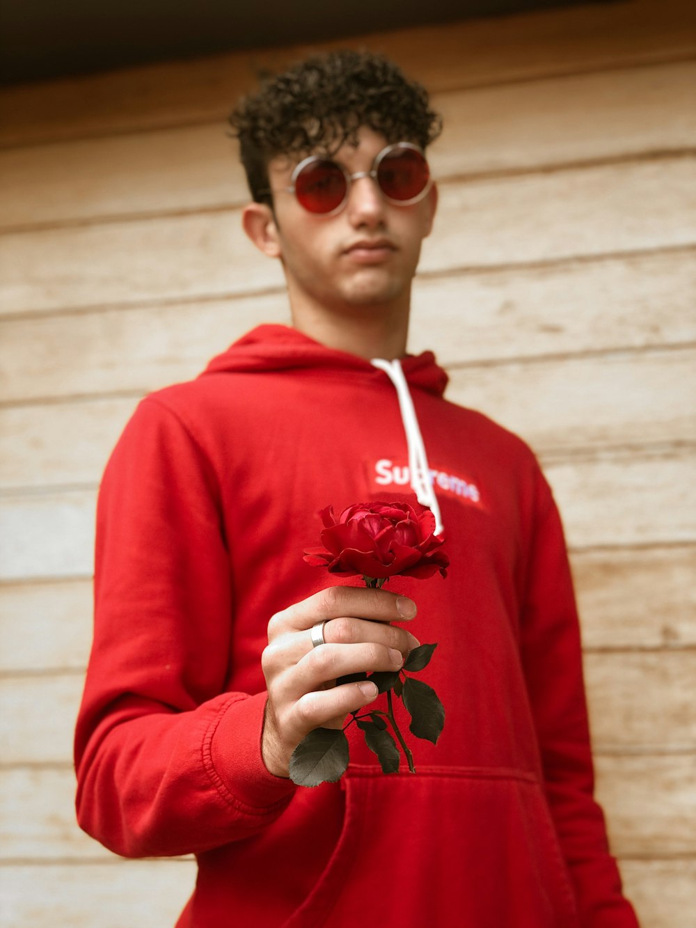 Hombre con sudadera con capucha roja con gafas de sol negras