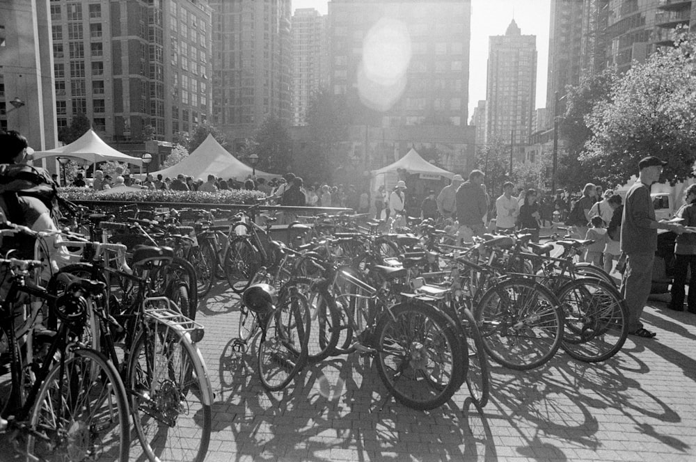 grayscale photo of bicycles parked on the side of the road