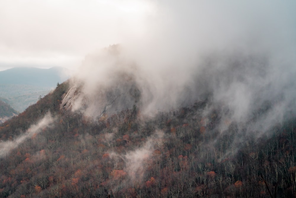 green and brown mountain covered with white clouds