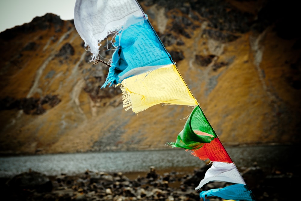 yellow green and red flag on rocky shore during daytime