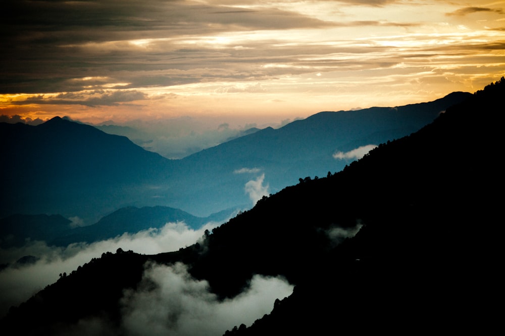 mountains under white clouds during daytime