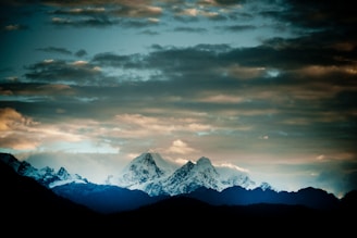 snow covered mountain under cloudy sky during daytime