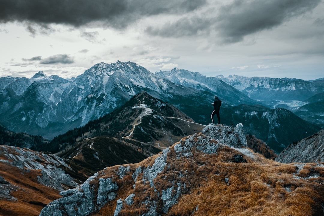 person standing on rock mountain during daytime