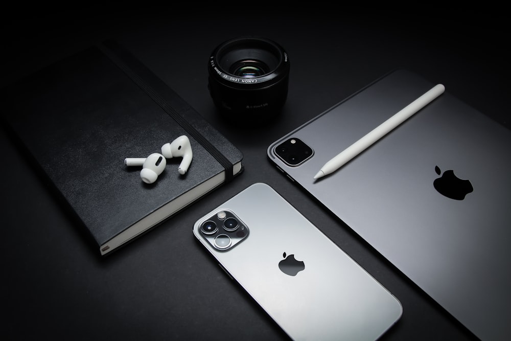 silver macbook beside black camera lens and black camera lens
