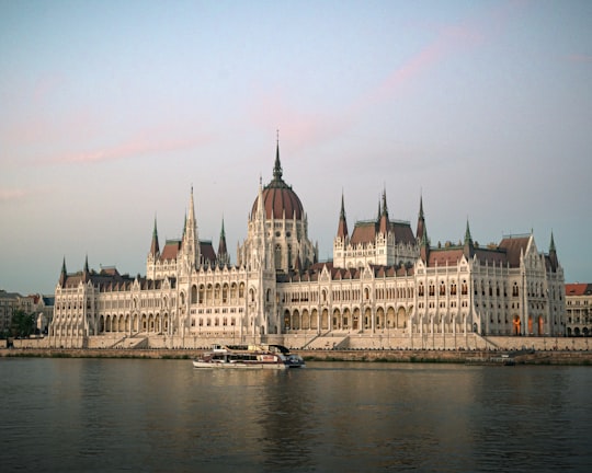 white and brown concrete building near body of water during daytime in Hungarian Parliament Building Hungary