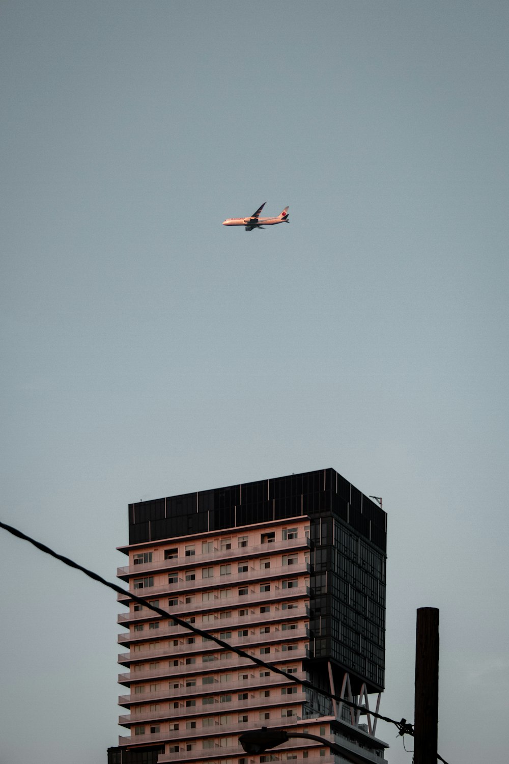 Rot-weißes Flugzeug fliegt tagsüber über die Stadt