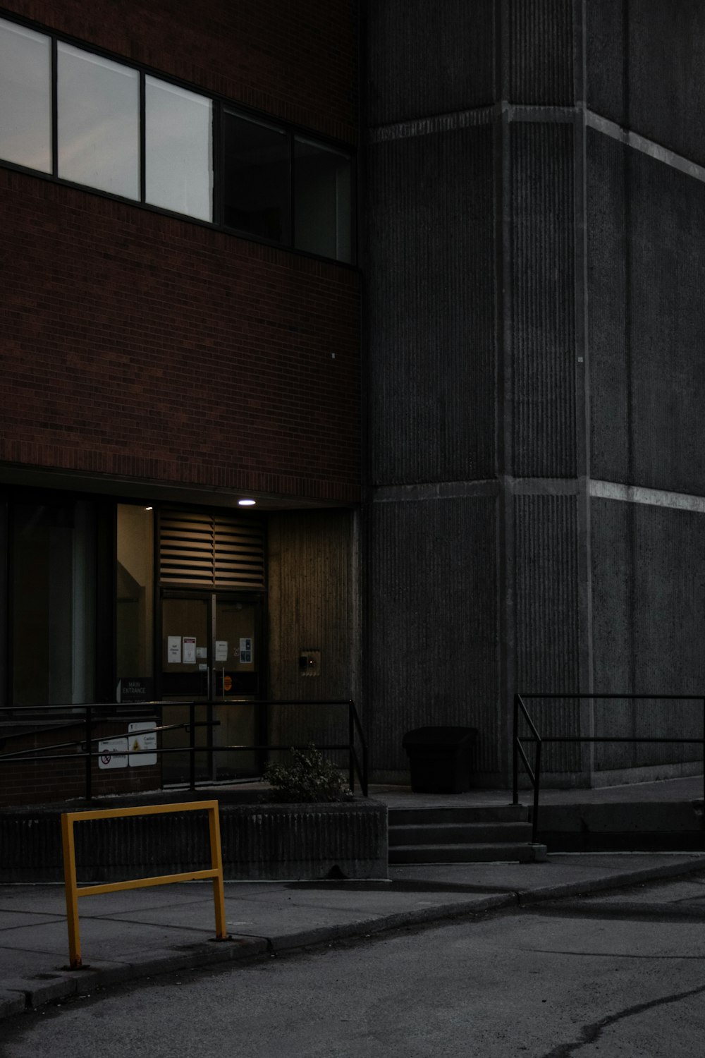 black and yellow metal bench near brown wooden building