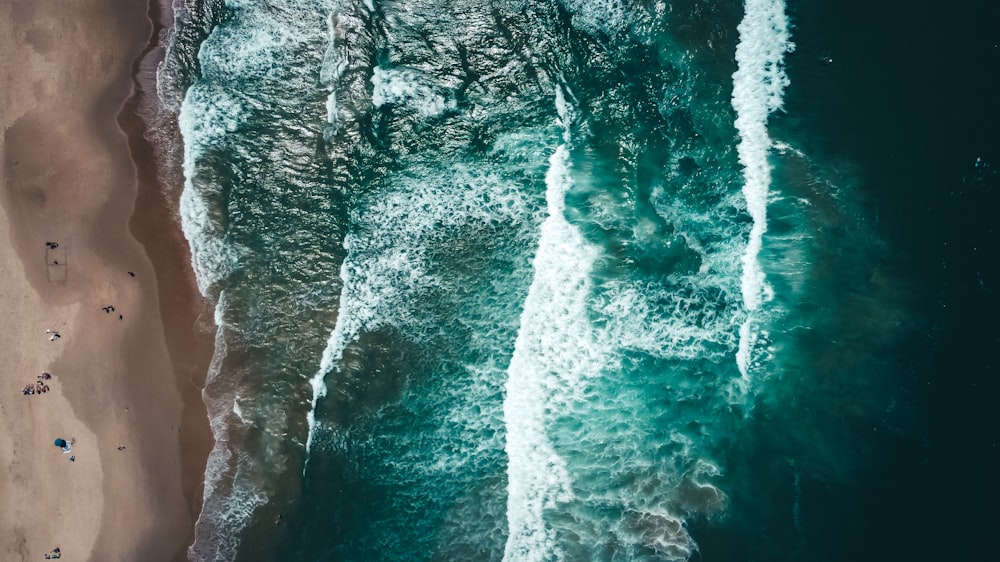 water waves hitting rocks during daytime