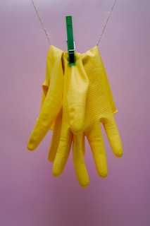 A pair of gloves drying on a garden fence post under the warm sun.