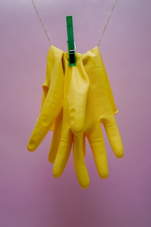A pair of gloves drying on a garden fence post under the warm sun.