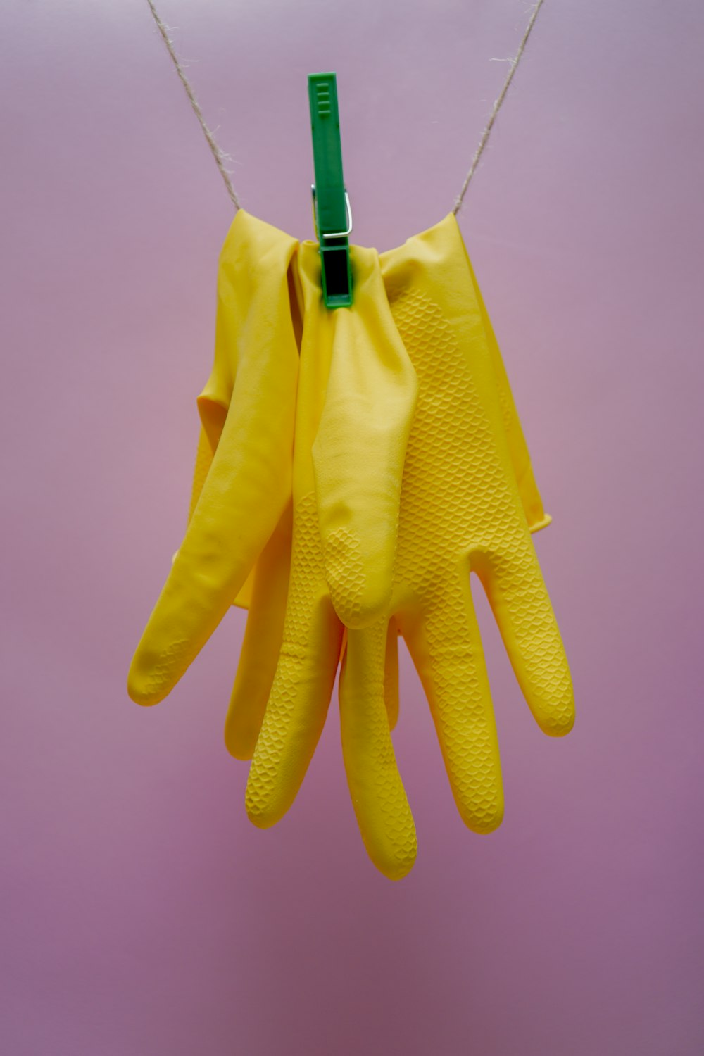 Gelbe Handschuhe am blauen Kleiderbügel