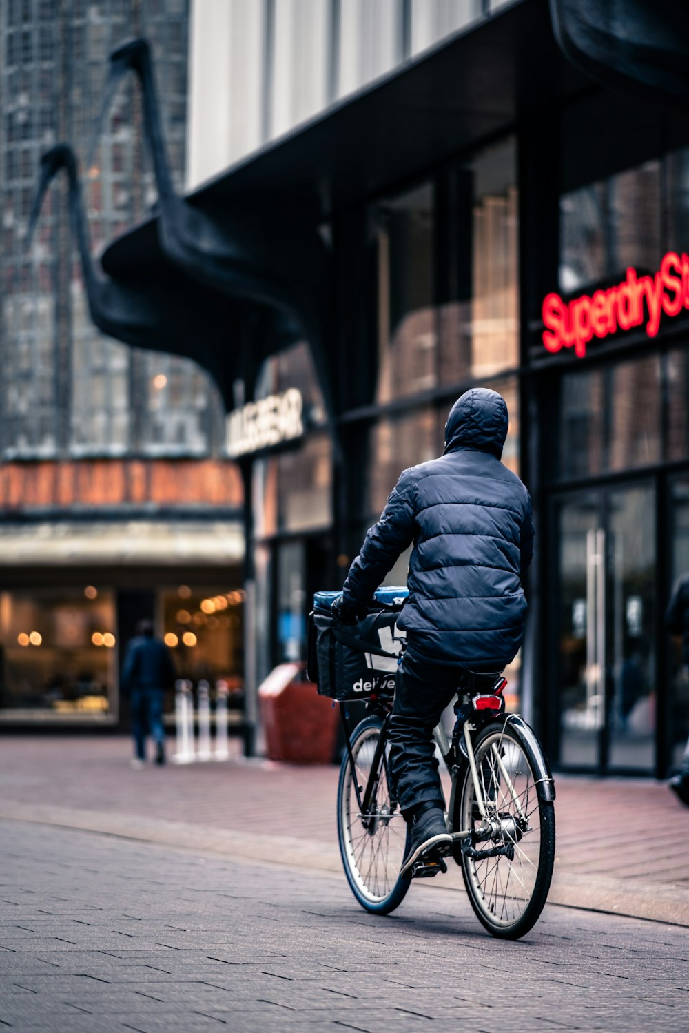 man in black leather jacket riding on bicycle during daytime