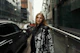A stylish young woman wearing Vixtta clothing, standing confidently in an urban mural backdrop.