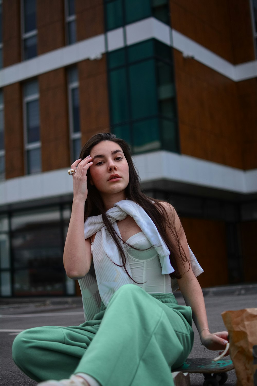 woman in white and green dress sitting on brown wooden bench during daytime