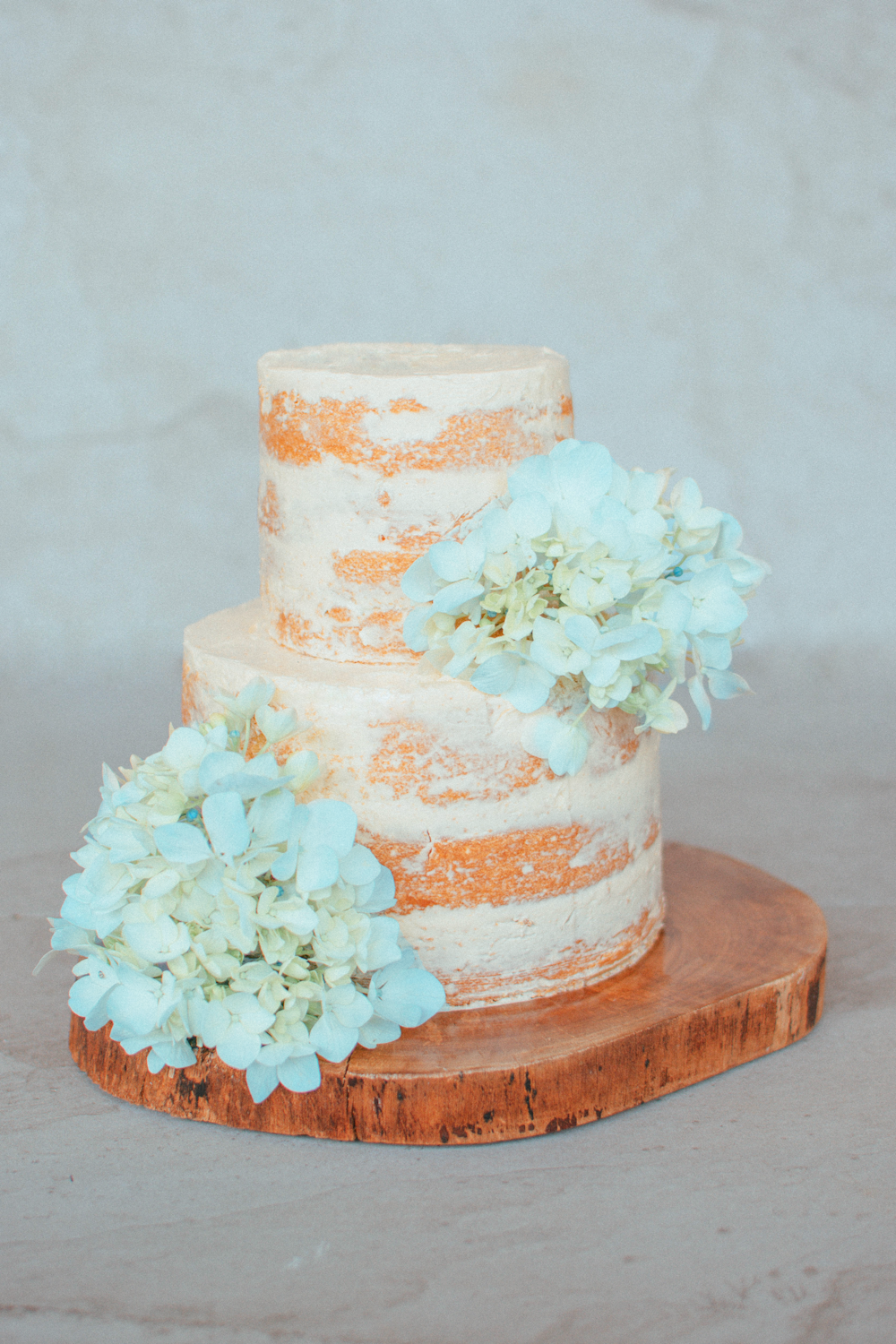 3 layer cake with white flowers on brown wooden table