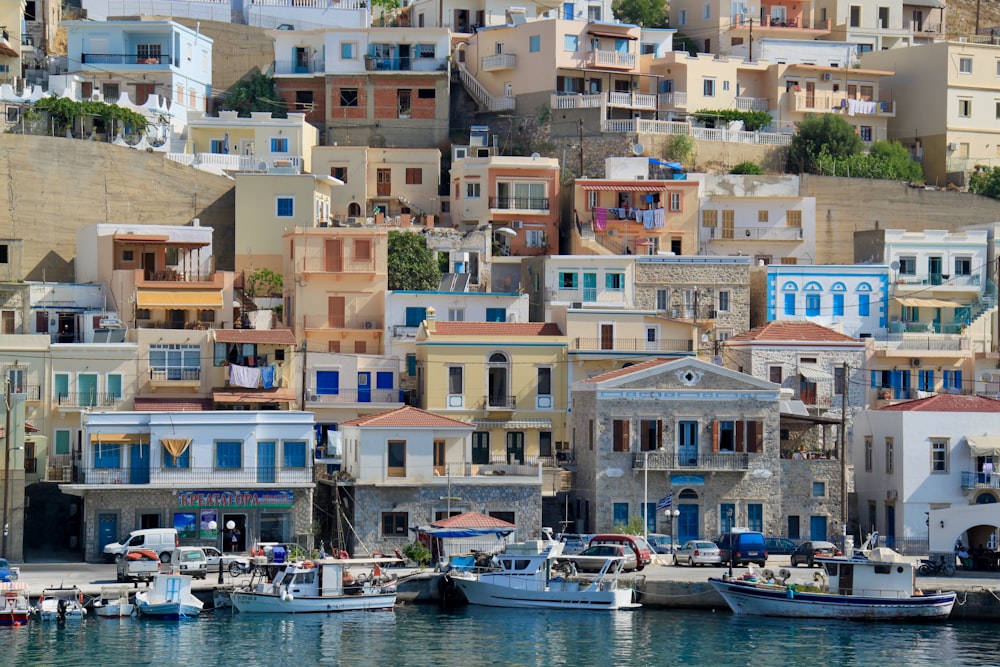 white and blue boat on dock near buildings during daytime