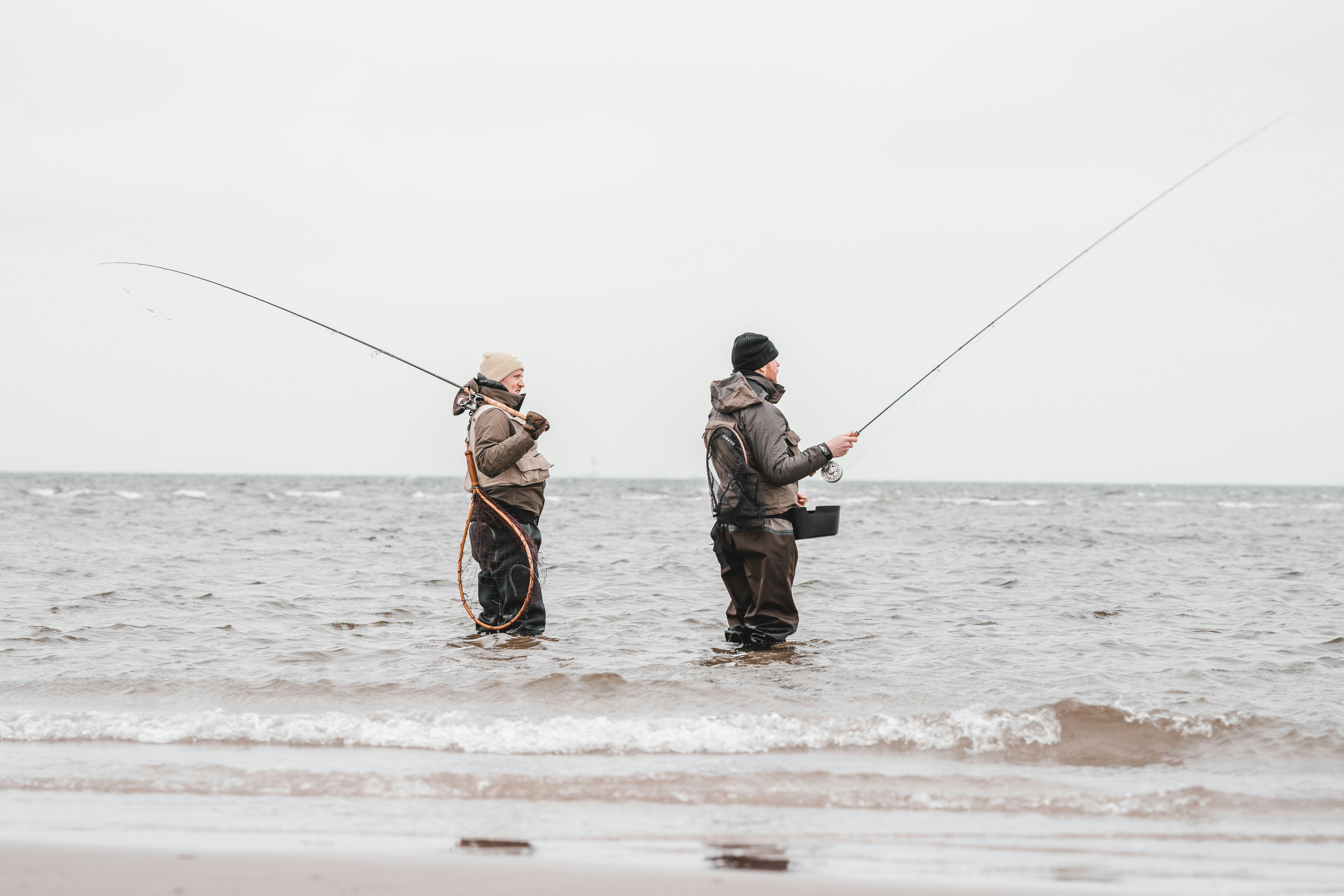 2 men fishing on sea during daytime