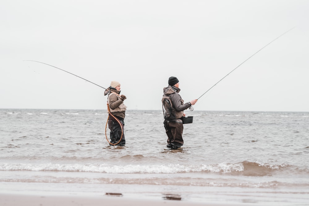 2 men fishing on sea during daytime