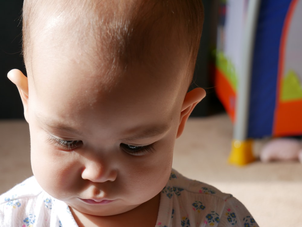 baby in white and blue floral shirt