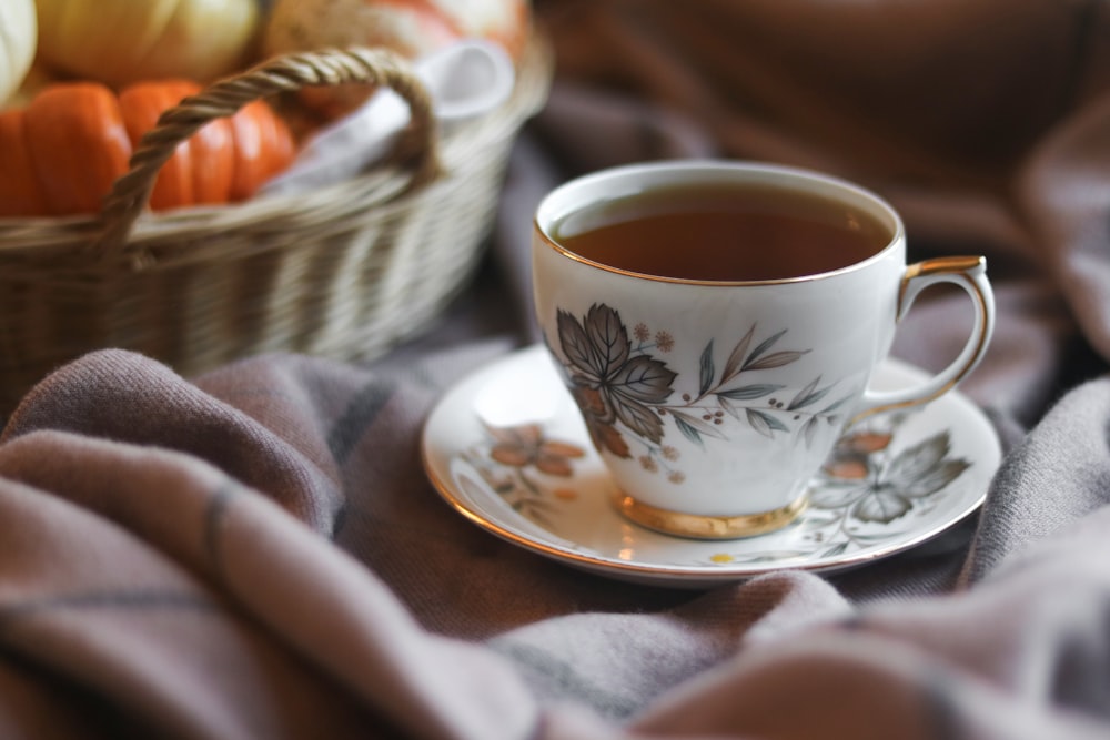 white and black floral ceramic cup on saucer