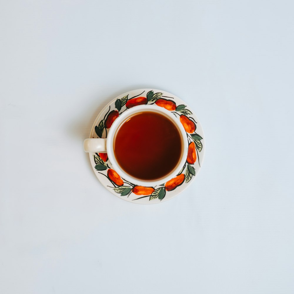 Tazza in ceramica bianca, rossa e verde con liquido marrone