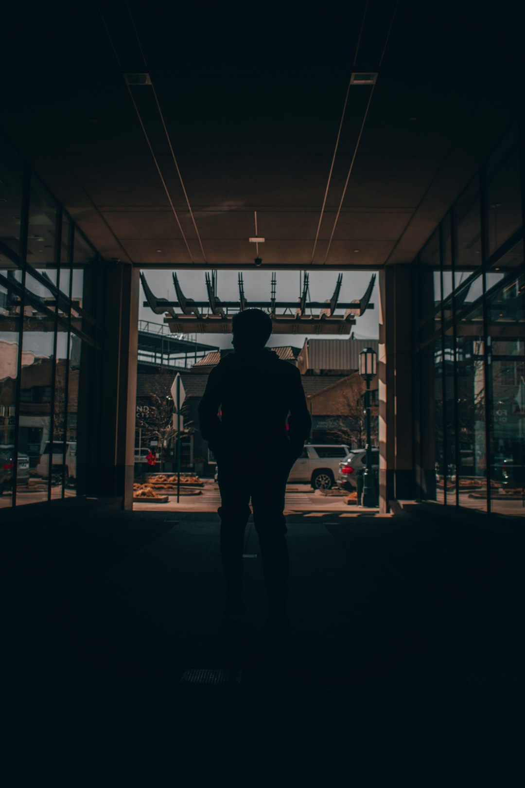 man in black jacket standing in front of store during night time