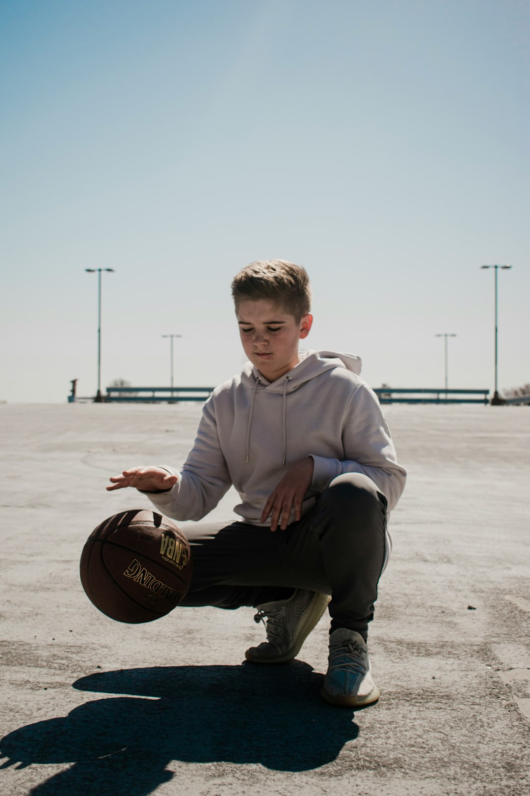 boy in white hoodie holding basketball