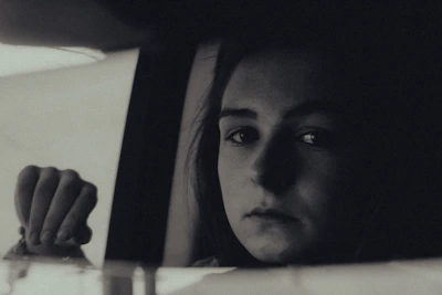 An intimate portrait of a person lost in thought by a window.