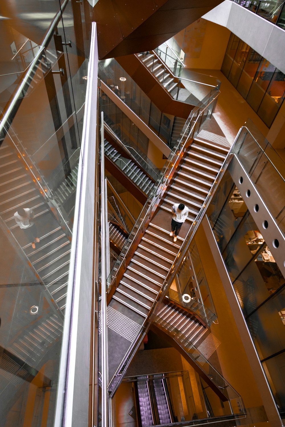 brown wooden staircase with stainless steel railings