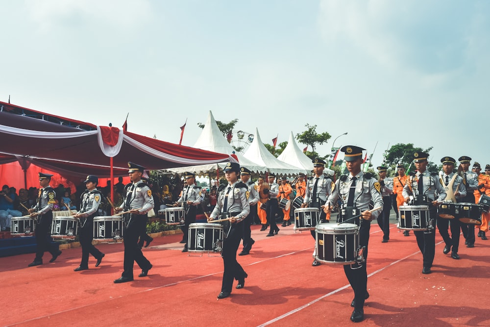 people in red and white uniform playing instruments