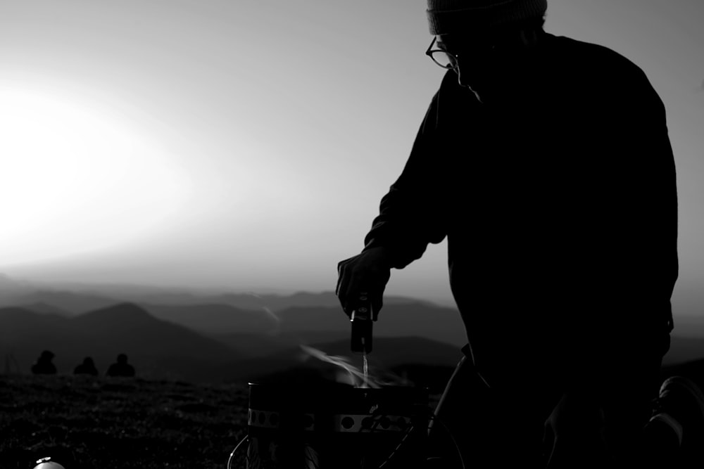 man in black jacket holding a black and white photo