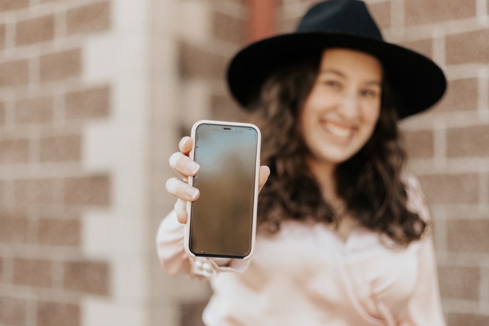 woman in white long sleeve shirt holding silver iphone 6