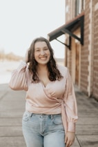 woman in pink long sleeve shirt and blue denim shorts smiling