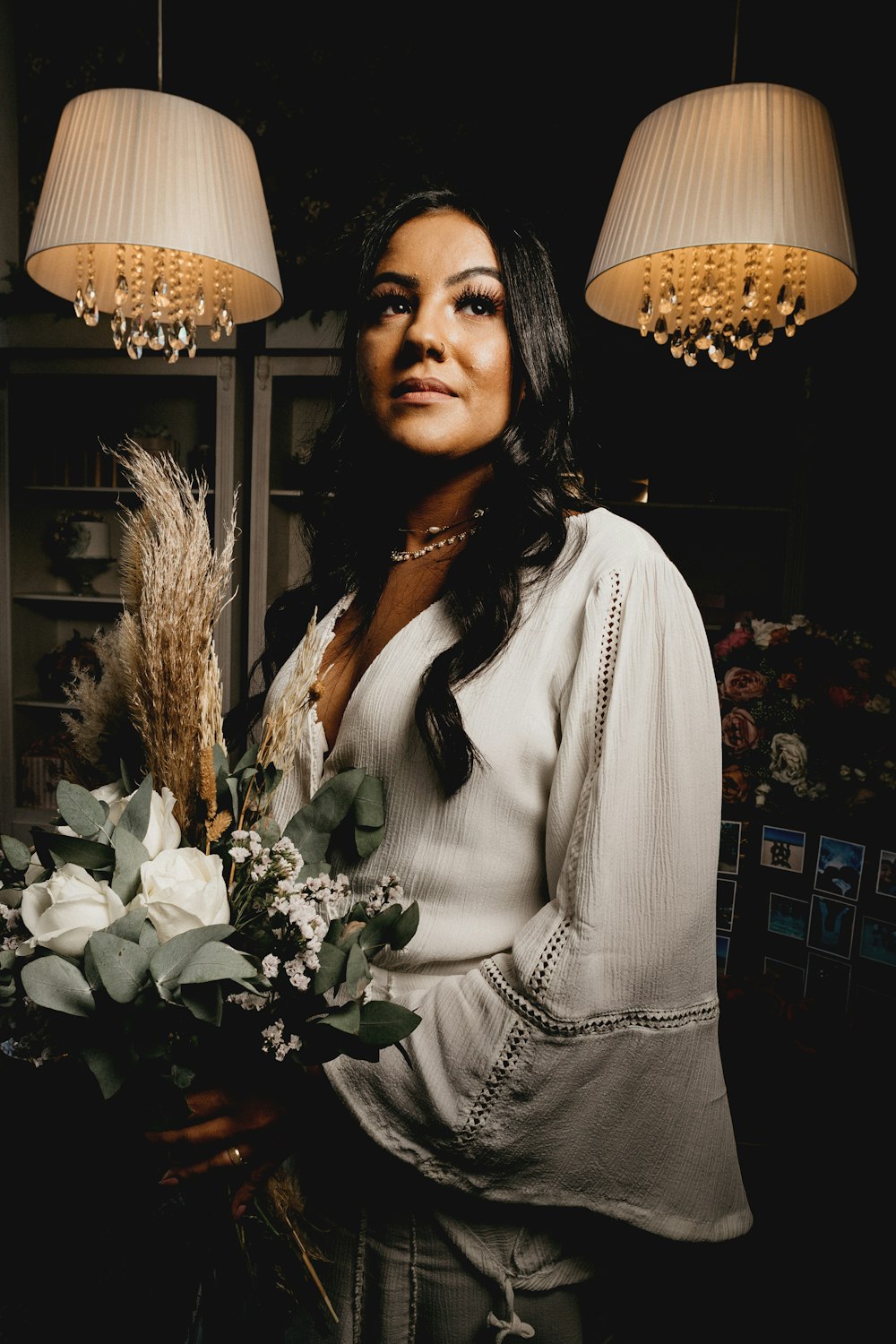 woman in white long sleeve shirt standing beside white flowers