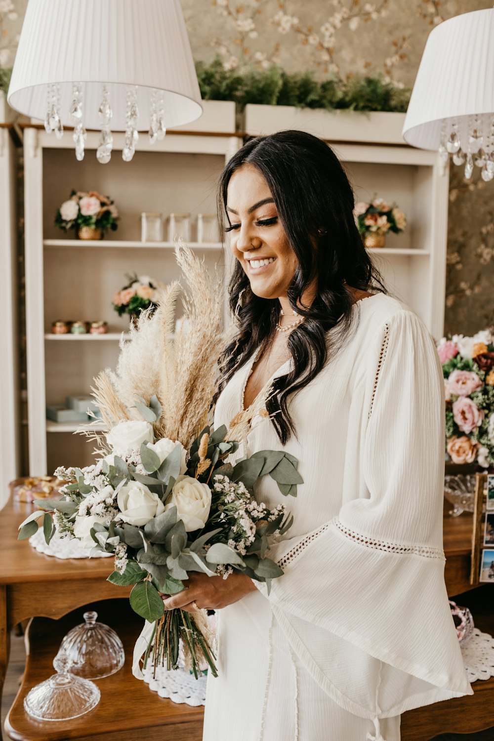 woman in white long sleeve shirt holding white flowers