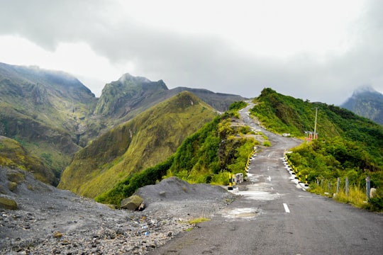 gray asphalt road between green mountains during daytime in Kediri Indonesia