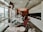 A modern dental clinic interior with dental chairs lined up near large windows, bright overhead lighting, and cabinetry. The room is well-organized and appears clean and professional, with a neutral color scheme and urban city view through the windows.