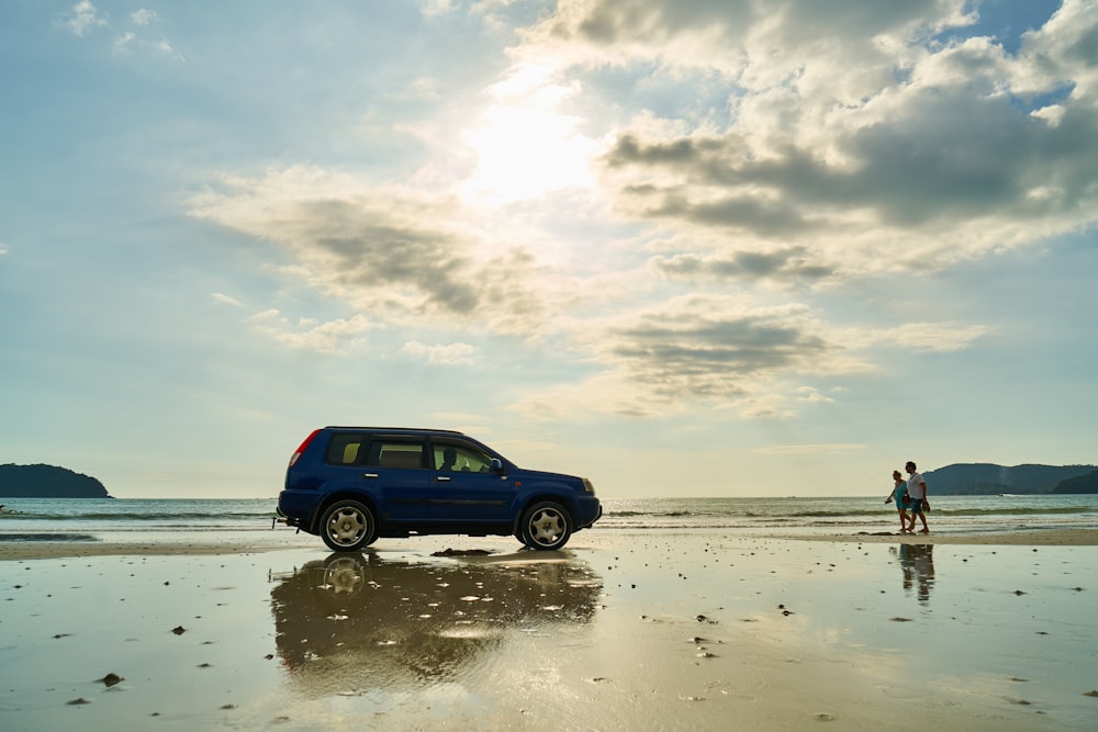 blue suv on beach during daytime