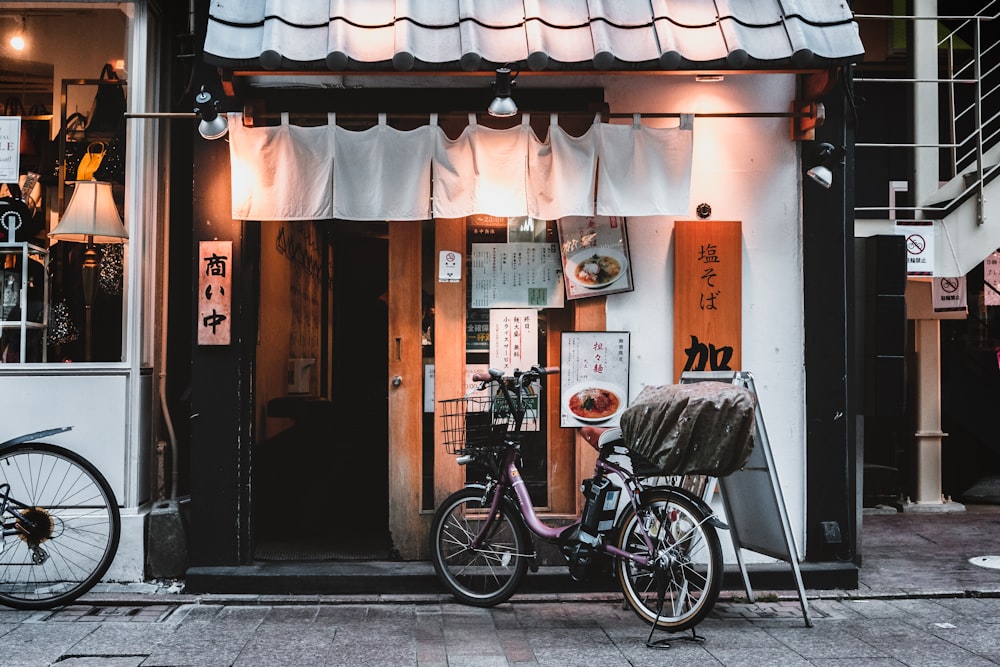 black bicycle parked beside brown wooden door