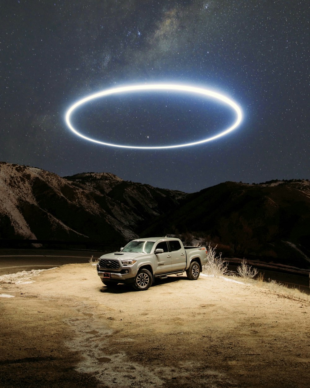 별이 빛나는 밤 아래 갈색 모래 위에 흰색 SUV