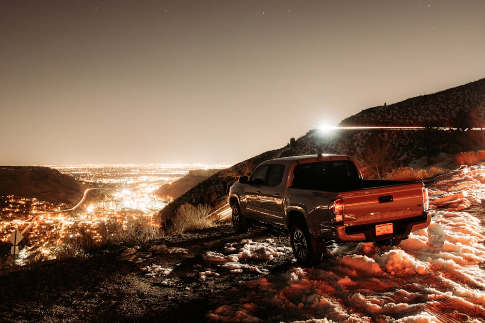 red crew cab pickup truck on brown field during daytime