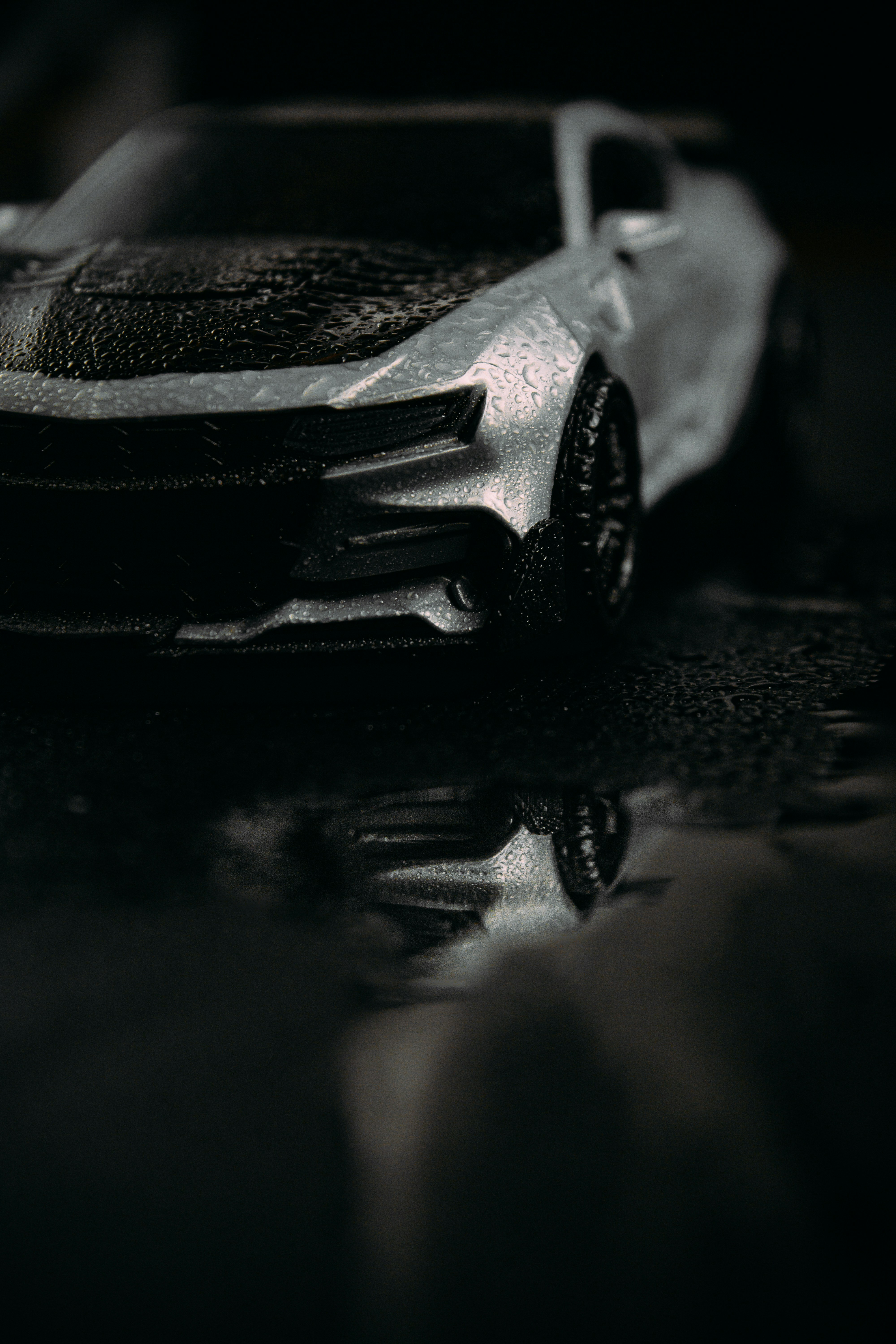 Silver sports sedan on wet surface with perfect reflection, night-time automotive shot, polished exterior finish