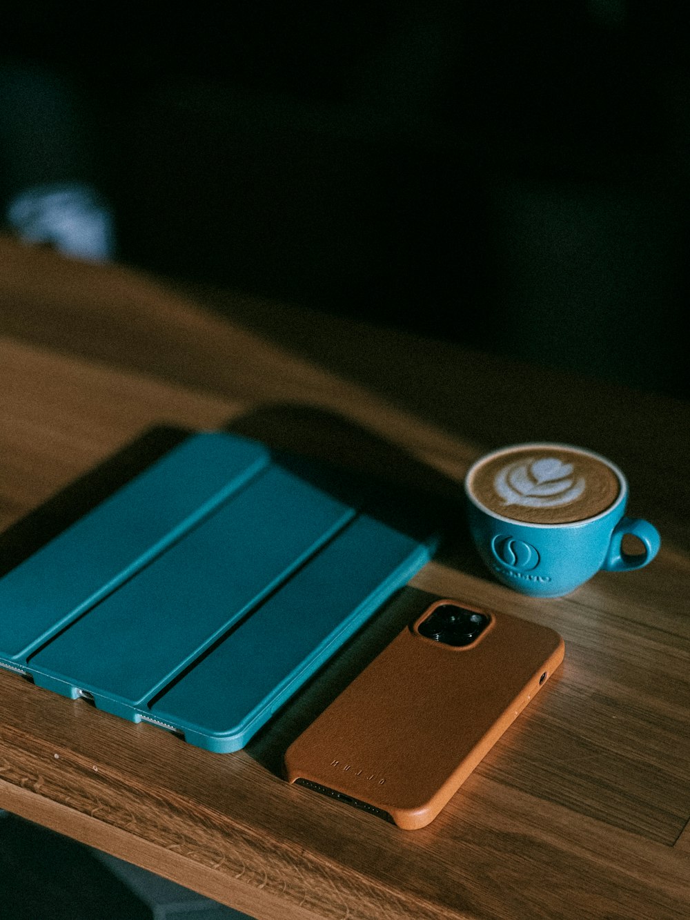 blue and brown leather flip case on brown wooden table