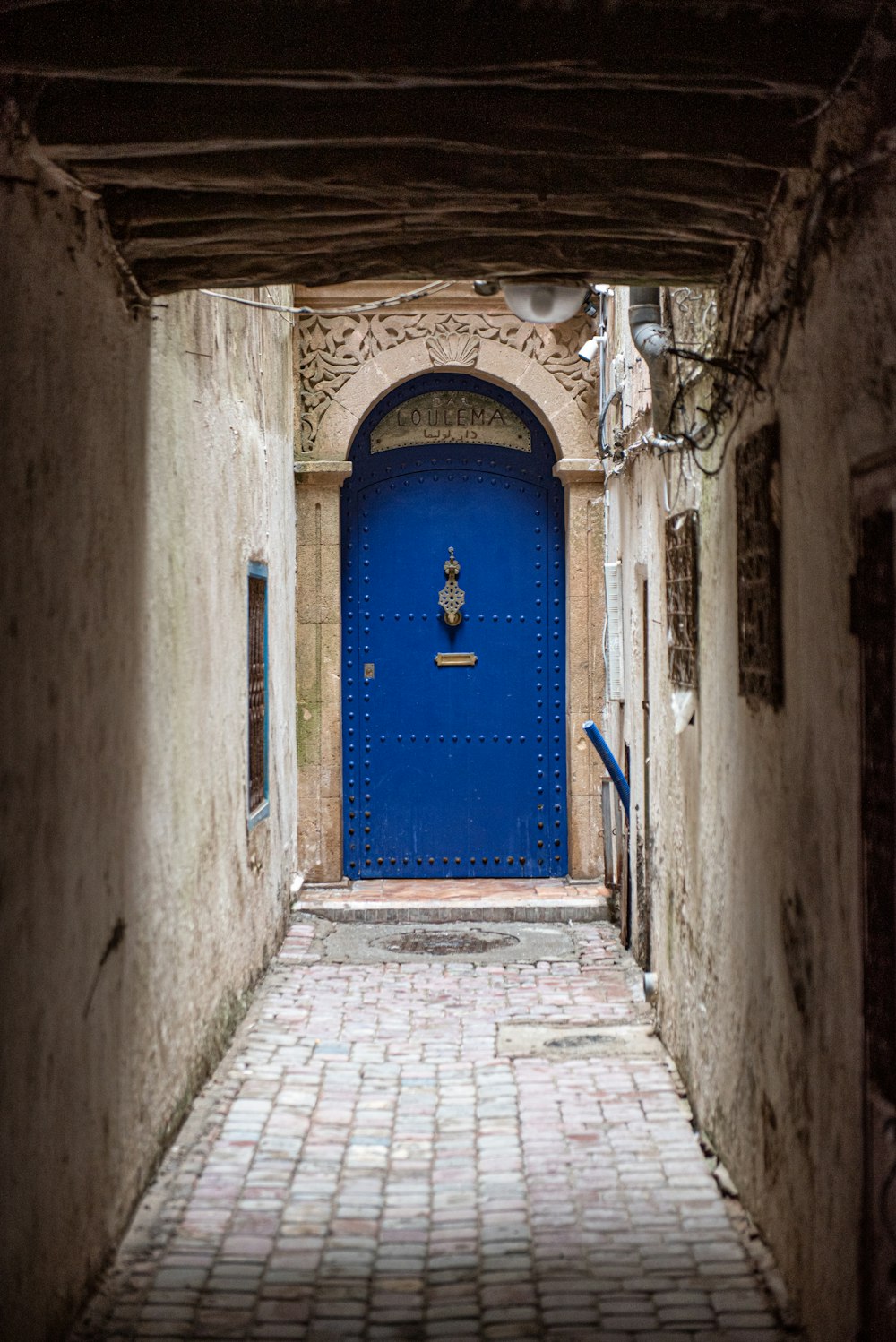 a blue door in a narrow alley way